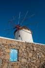 A traditional windmill set behind a rock masonry wall Chora-Mykonos Island-Greece Art Print